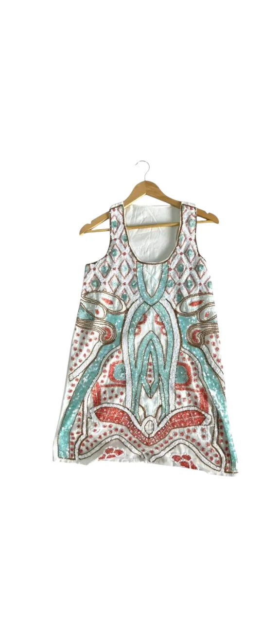 Vestido corto, holgado de sisa y pecho, con lentejuelas y canutillos bordados. Diseño único y llamativo, ideal para fiestas o eventos especiales. Su estilo moderno y vibrante te hará destacar.