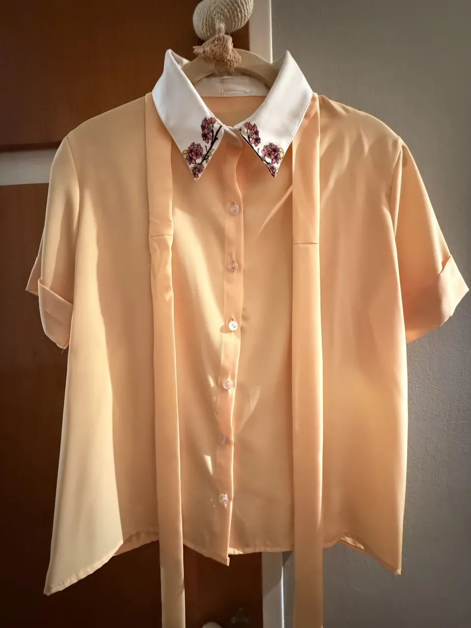 blusa de seda color amarillo vainilla con cuello blanco y detalle de flores estampadas. Posee mangas cortas y lazo largo al cuello que se puede quitar. El logo de la marca estaba estampado sobre una etiqueta de organza que con el tiempo se borró. Lo aclaro porque no se puede leer.  Tiene un solo uso asiqie está impecable. 