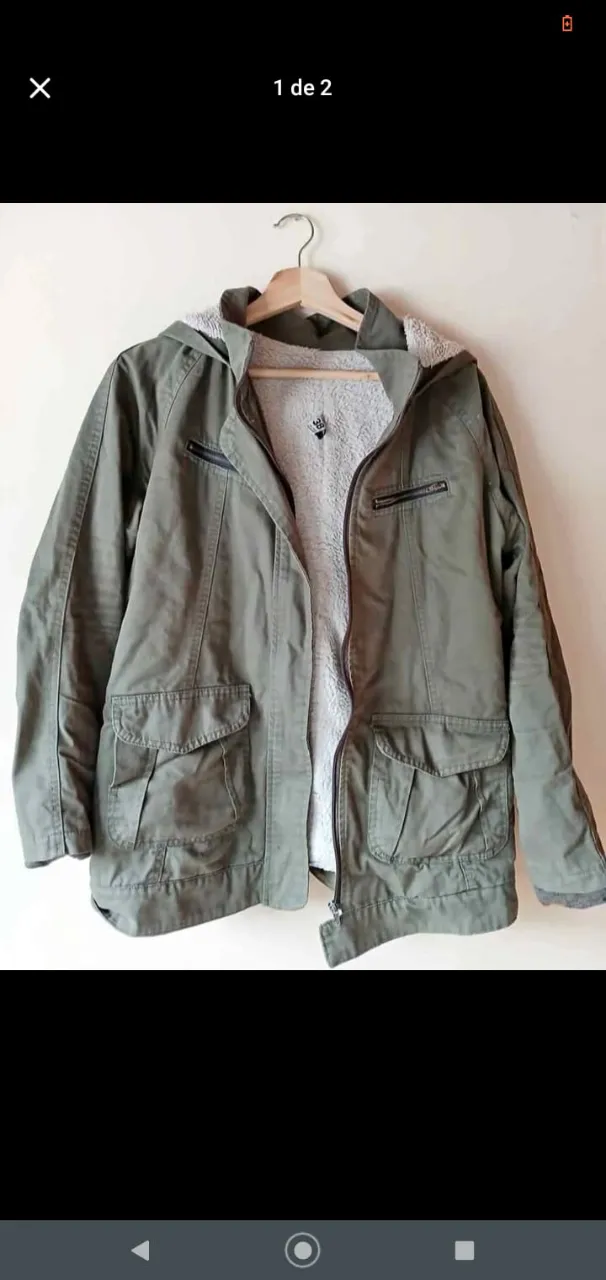 Campera verde militar con capucha y forro de piel sintética. Posee bolsillos amplios y cierre frontal. Ideal para el invierno.
