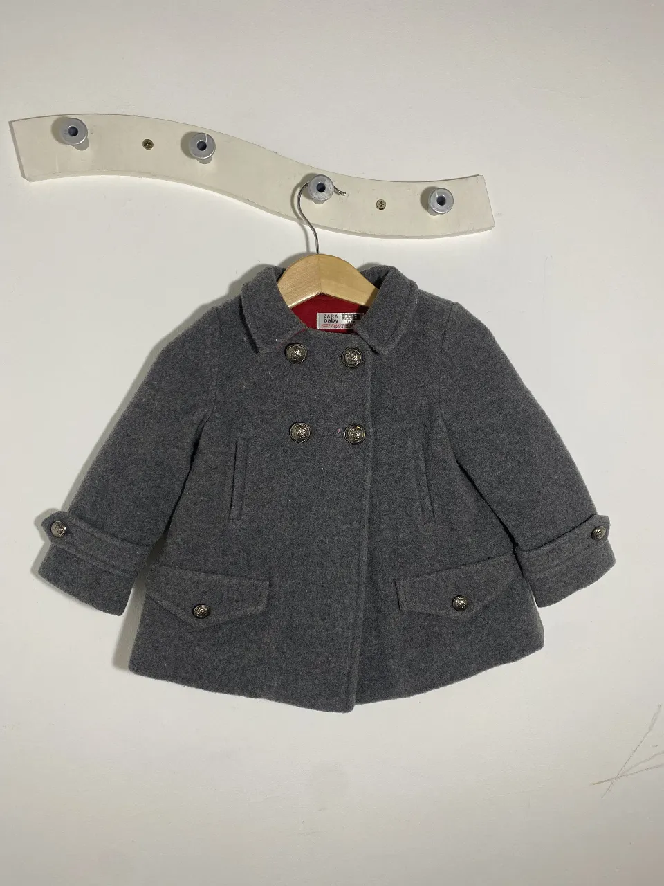 Abrigo gris de paño para niña, estilo clásico con botones y bolsillos. Ideal para el invierno, perfecto para un look elegante y abrigado.