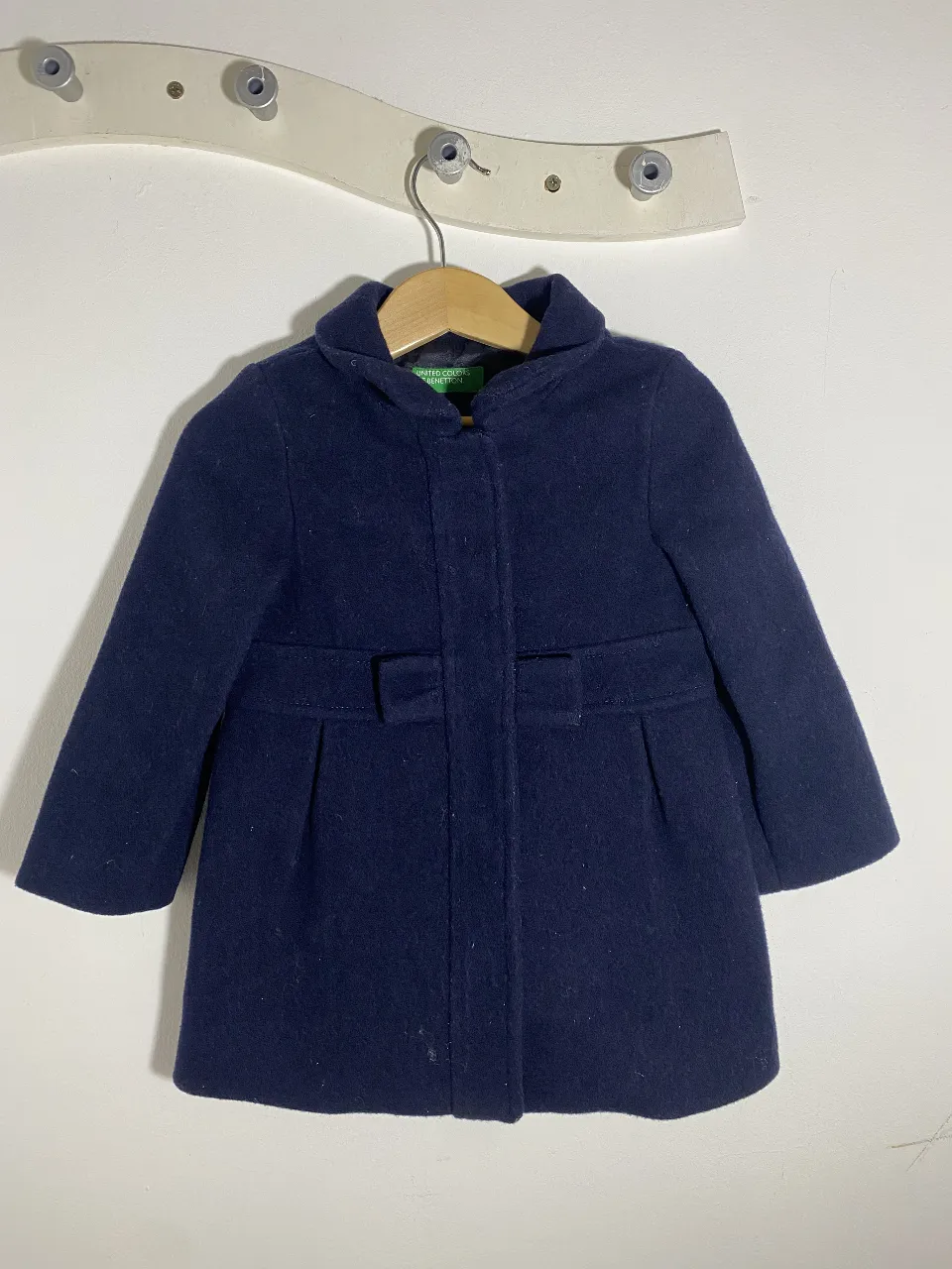 Tapado de niña azul marino, con diseño de moño en la cintura. Ideal para el invierno, abrigo y estilo en una sola prenda.