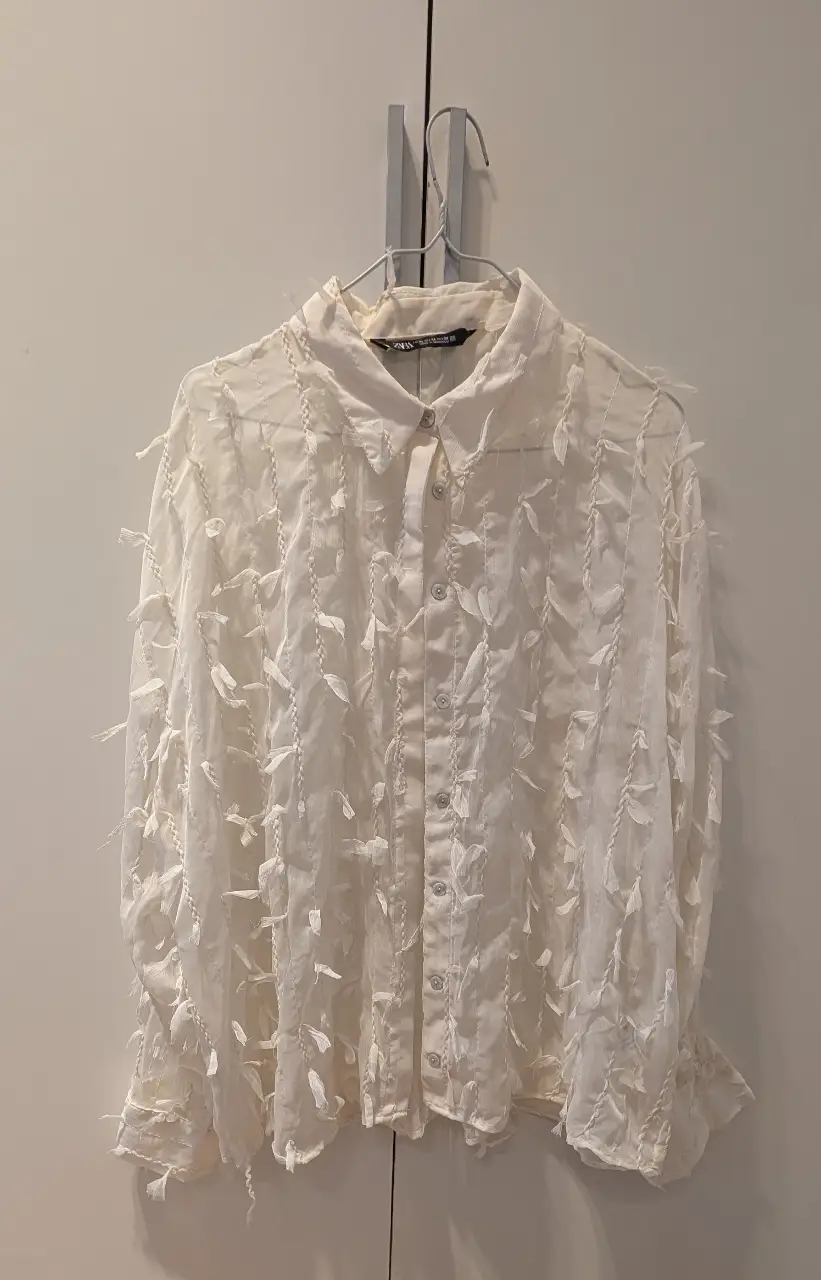 Blusa de la marca Zara, color blanco con detalles de volados y mangas largas. Talle XL, ideal para un look elegante y sofisticado.