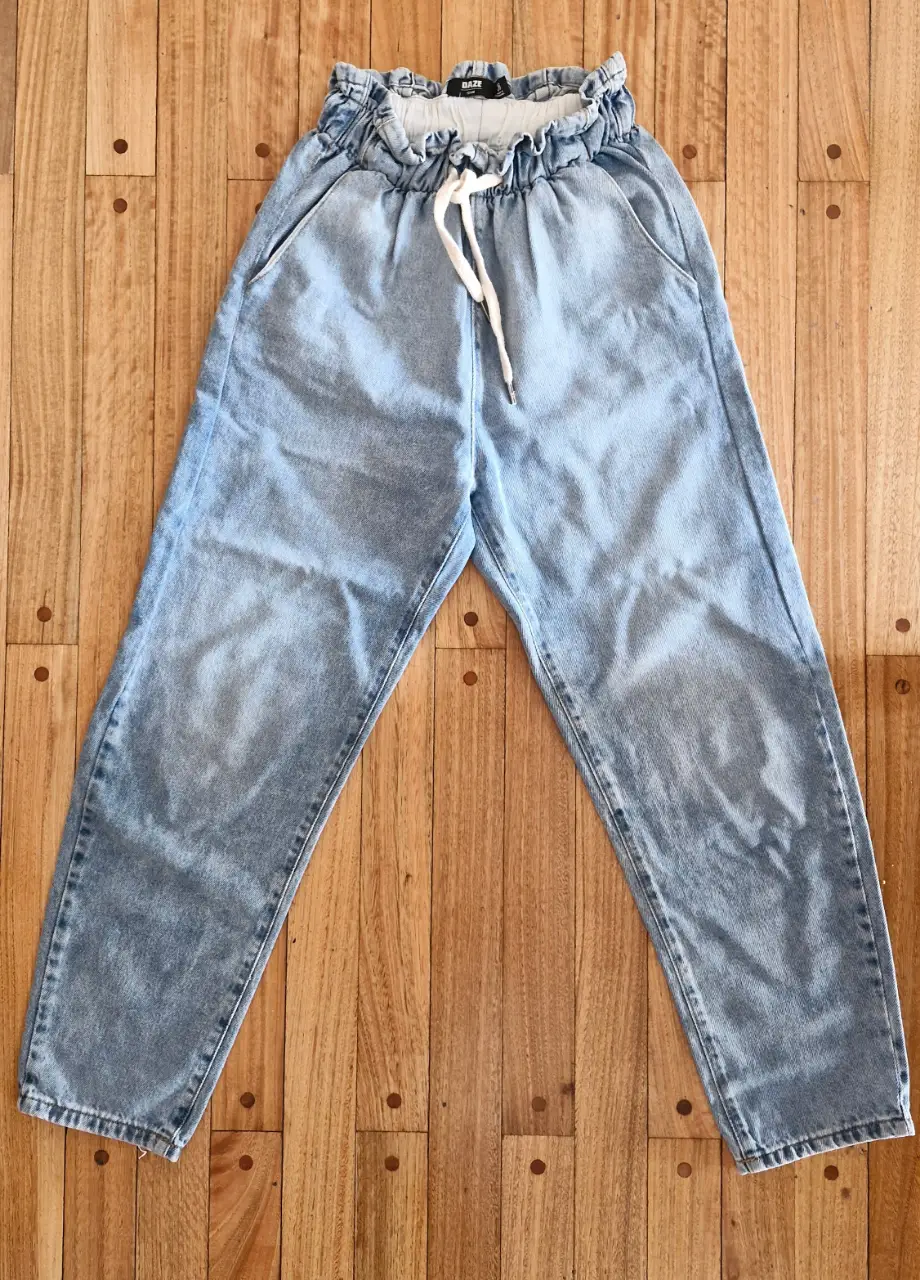 Pantalón de jean celeste, tiro alto, con cintura elastizada y cordón. 