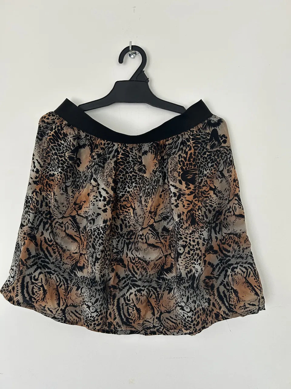 Pollera corta con estampa animal print de tigres y leopardos. Posee cintura elastizada negra.