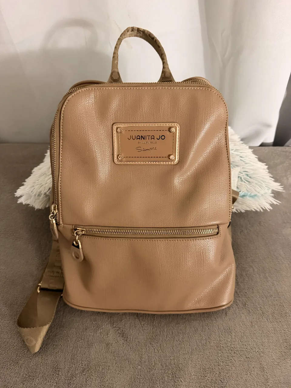 ¡Impresionante mochila de cuero sintético color suela! Perfecta para el día a día, con un diseño moderno y práctico. Su interior forrado con un estampado exclusivo de la marca le da un toque chic. ¡Ideal para llevar todo lo que necesitás con estilo!