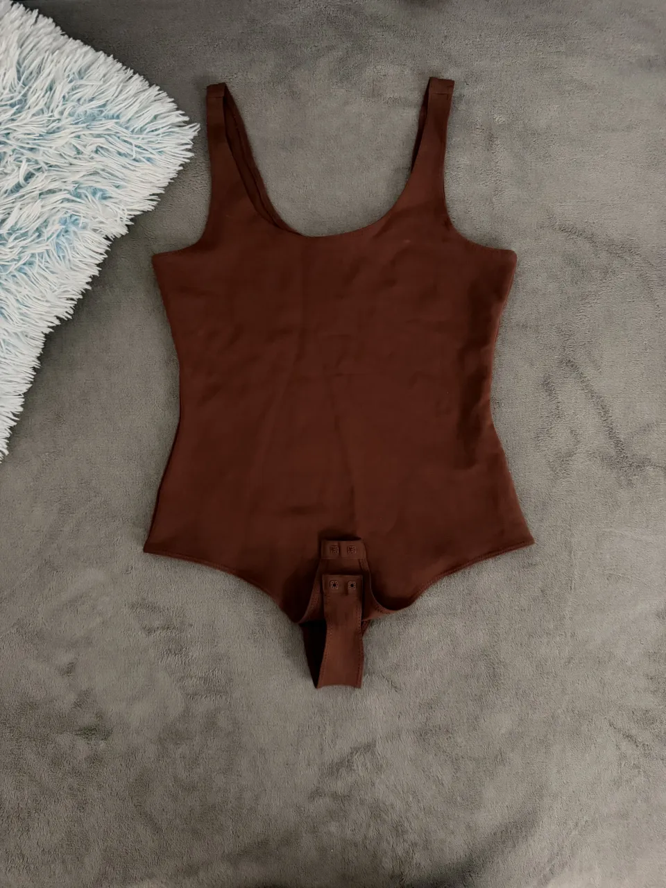 Body de tiras finas, escote redondo y broches inferiores. Un básico súper cómodo y versátil para tu día a día.