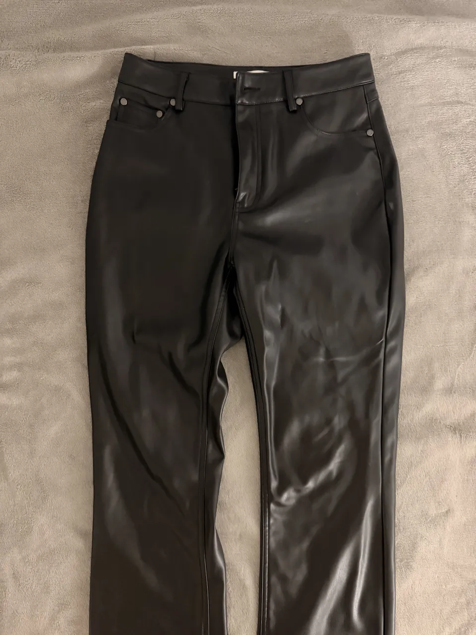Pantalón de cuero negro tiro alto, corte recto y moderno. Ideal para un look canchero y con onda.