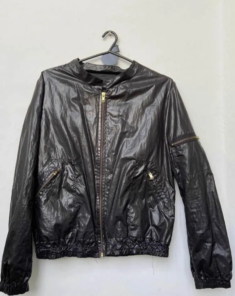 Campera bomber negra brillante, con cierre y bolsillos. Forrada. Ideal para un look moderno y canchero.