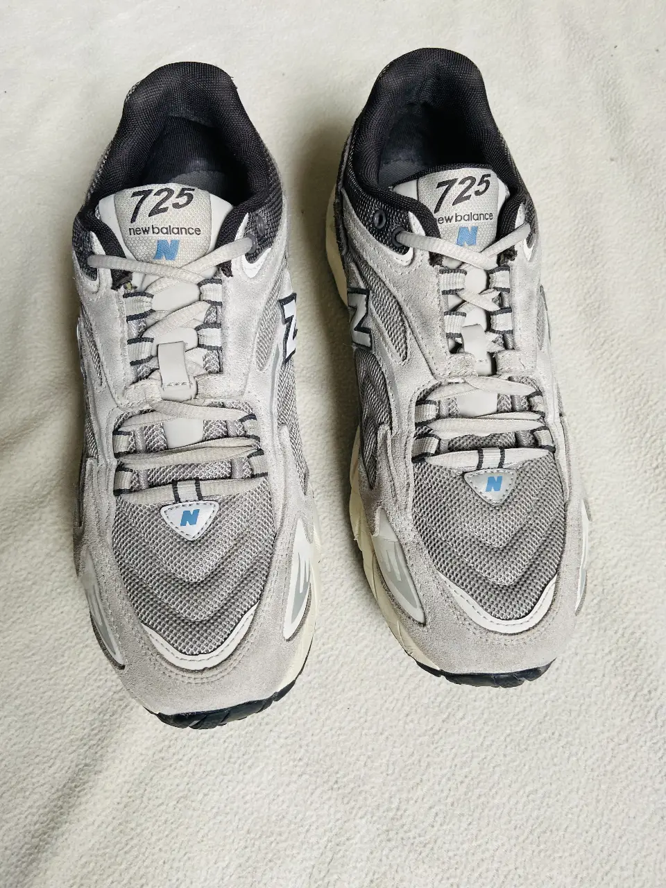 Zapatillas New Balance 725 grises y blancas, ideales para uso diario. Diseño retro y cómodo.