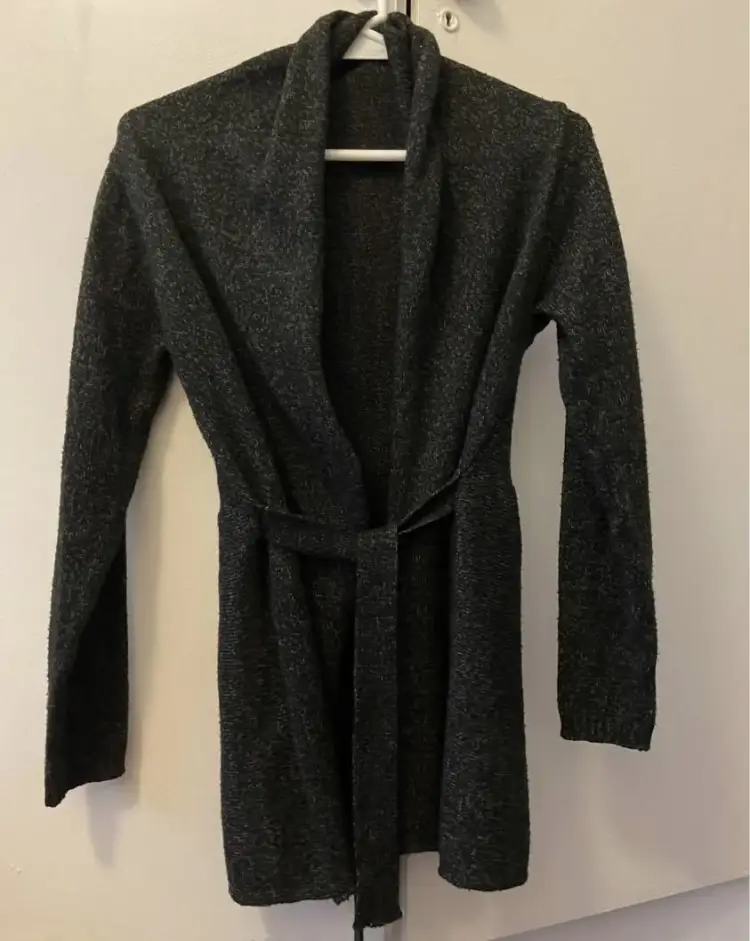 Cardigan largo de tejido grueso en color gris oscuro, con cinturón para ajustar a la cintura. Ideal para un look casual y abrigado.