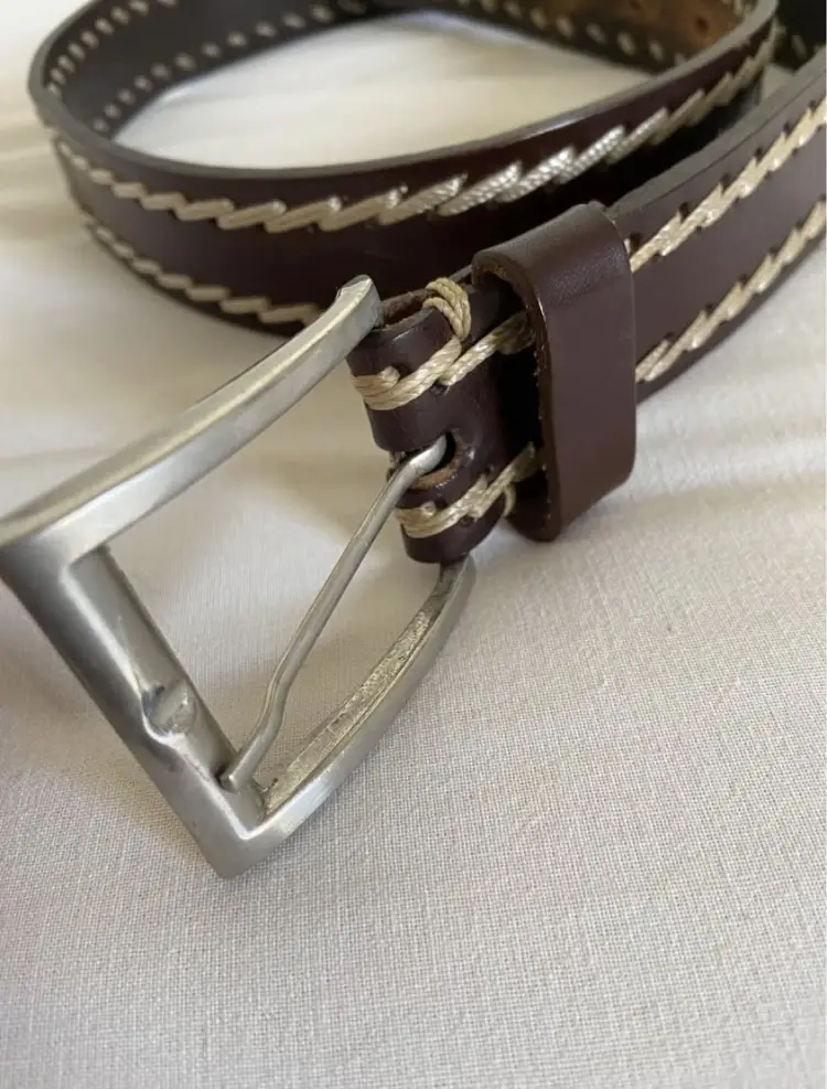 Cinturón de cuero marrón con costuras blancas y hebilla plateada. Talle 85, ideal para un look casual y duradero.