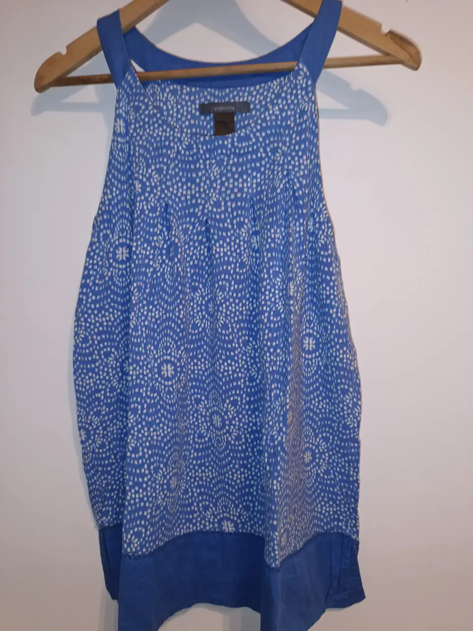 Remera / Blusa de mujer Liz Claiborne, con estampado floral en tonos azules y blancos. Diseño sin mangas con cuello redondo y detalle de tela lisa en la parte inferior. Ideal para un look fresco y casual. Talle M. buen estado. entre sisas:59cm Largo:77cm