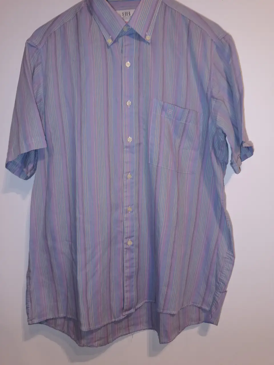 Camisa de hombre a rayas verticales en tonos celeste, lila y beige. Con bolsillo en el pecho y cuello con botones. Ideal para un look casual y fresco. Marca Balenciaga. talle42. excelente estado. entre hombros:49cm entre sisas:64cm Largo:76cm