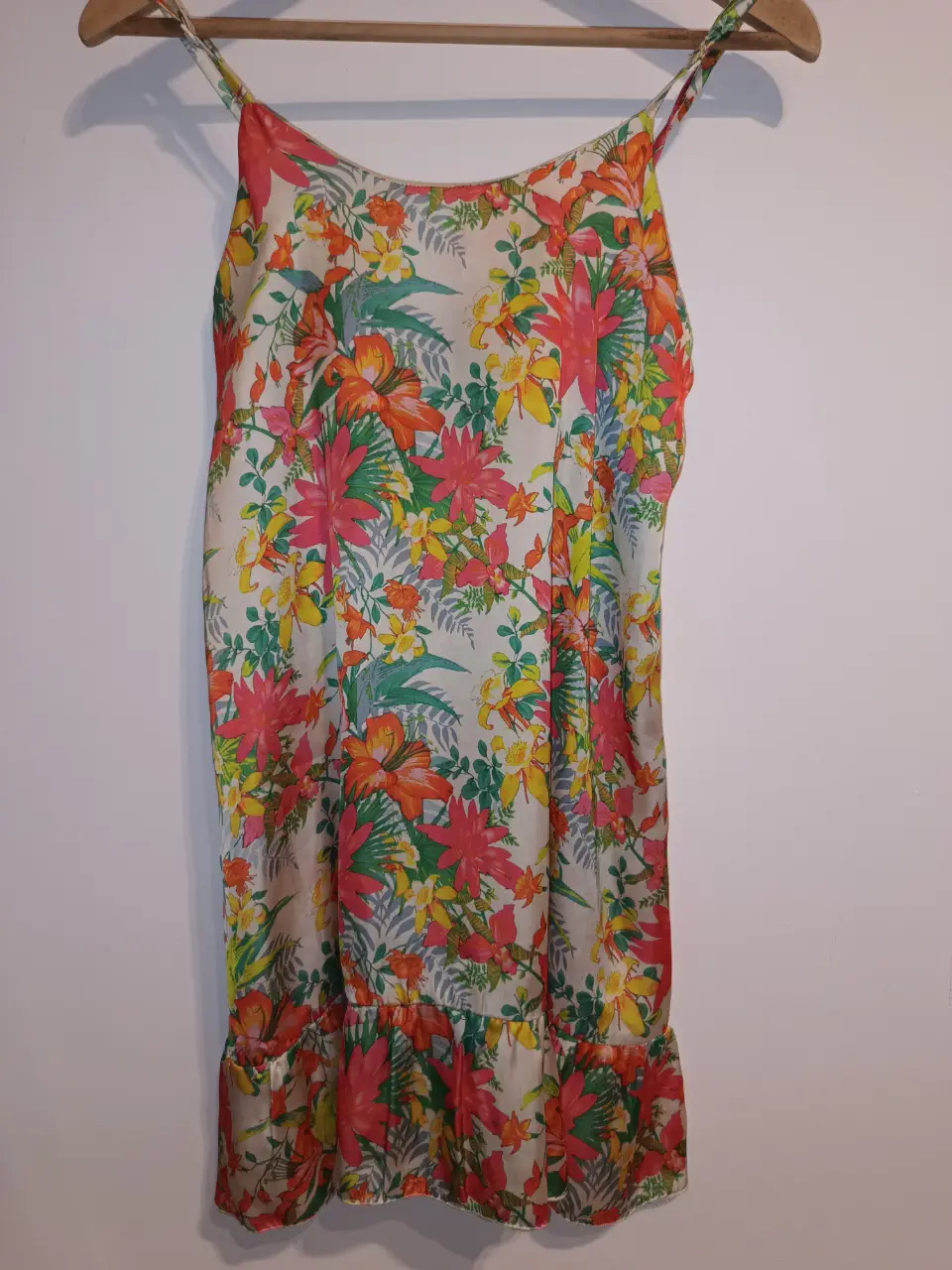 Vestido mini de verano con estampado floral. Tiene tirantes finos y un detalle de volado en el bajo. Ideal para un look fresco y femenino. confeccionado en satén. impecable. talle 38 entre sisas:39cm cadera:95cm Largo:80cm