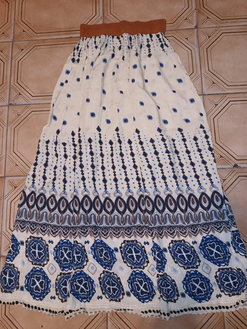 Pollera larga de mujer con estampado floral en tonos azules y crudo. Cintura elastizada en color marrón. Ideal para un look bohemio y fresco. Cintura sin estirar:66cm cede a 106 cm Largo:101cm. Excelente estado 