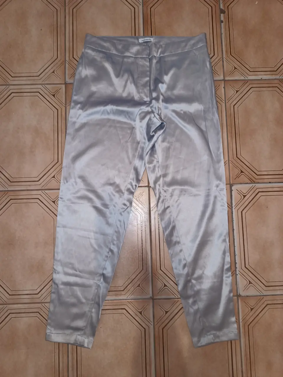 Pantalón sastrero de satén gris, tiro alto y corte recto achupinado. Ideal para un look elegante y sofisticado. Con bolsillos traseros. talle 38. Portsaid. Cintura:82cm Cadera:102cm Tiro del:24cm Largo:94cm ancho botamanga:14cm
