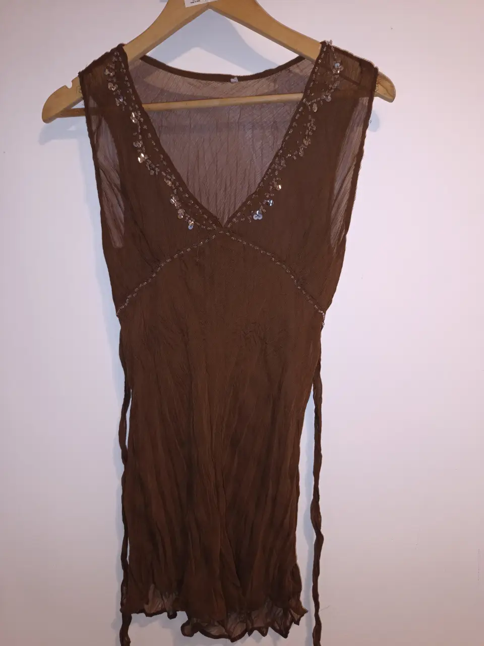 Blusa marrón con escote en V y detalles de lentejuelas. Ideal para una salida elegante. De gasa arrugada. con lazo para la cintura. muy buen estado. Entre sisas:55cm Largo:75cm