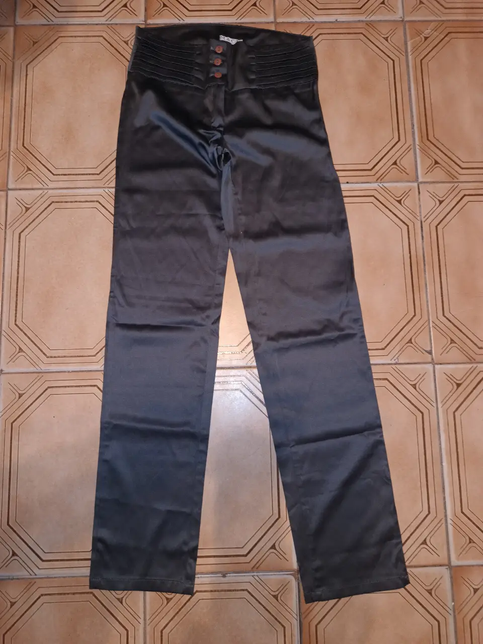 Pantalón sastrero de satén gris oscuro con cintura alta y detalles plisados. Ideal para un look elegante y sofisticado. Cintura alta:74cm Cadera:90 cm Tiro del:23cm Largo:101 cm ancho botamanga:17cm