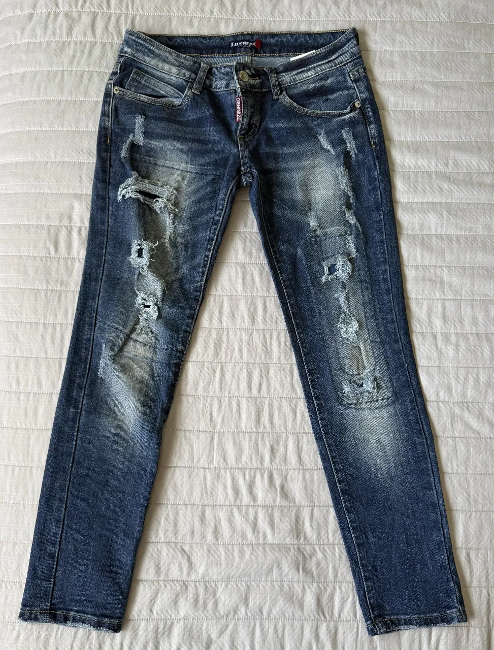 Jeans de mujer, talle M, tiro bajo, con roturas y detalles desgastados. Calce skinny. Marca Luxury-Q. 
84 cm de cintura - 86 cm de largo - 92 cm de contorno cadera. 