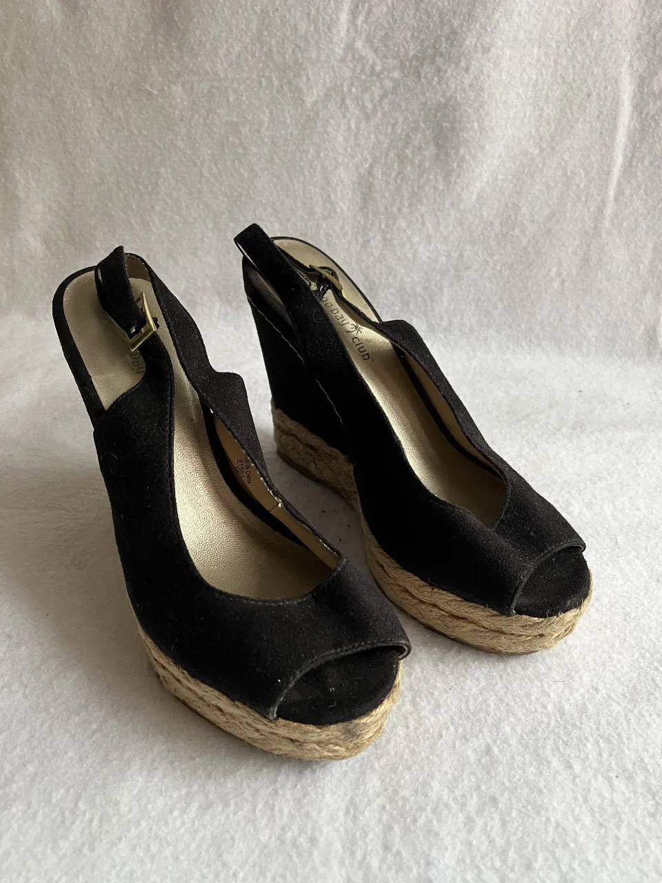 Sandalias de cuña negras con detalle de yute en la suela y tira en el tobillo. Ideales para un look casual y cómodo.