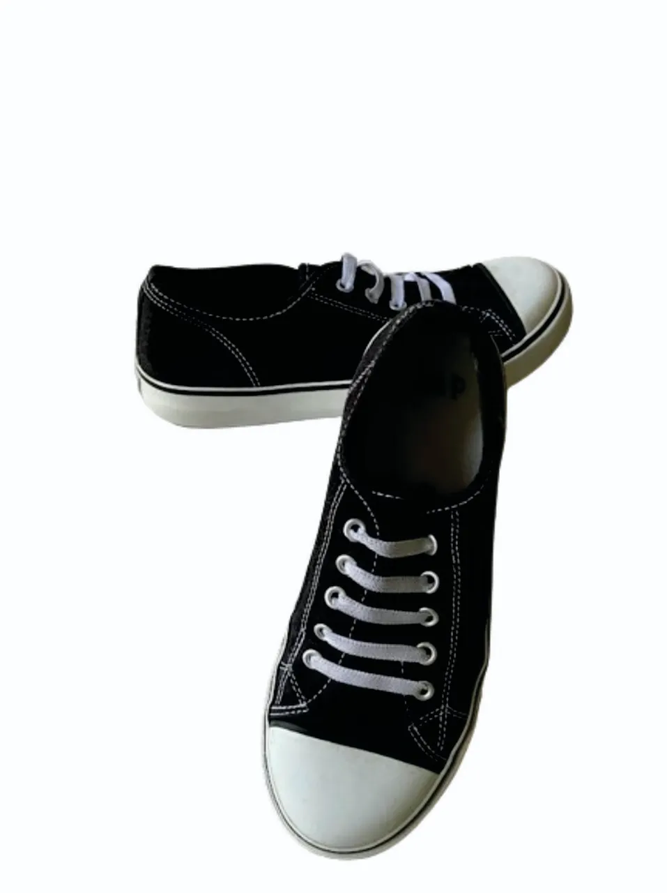 Zapatillas de lona negras con puntera blanca y cordon elástico blanco. Talle US4. Ideales para un look casual y cómodo.