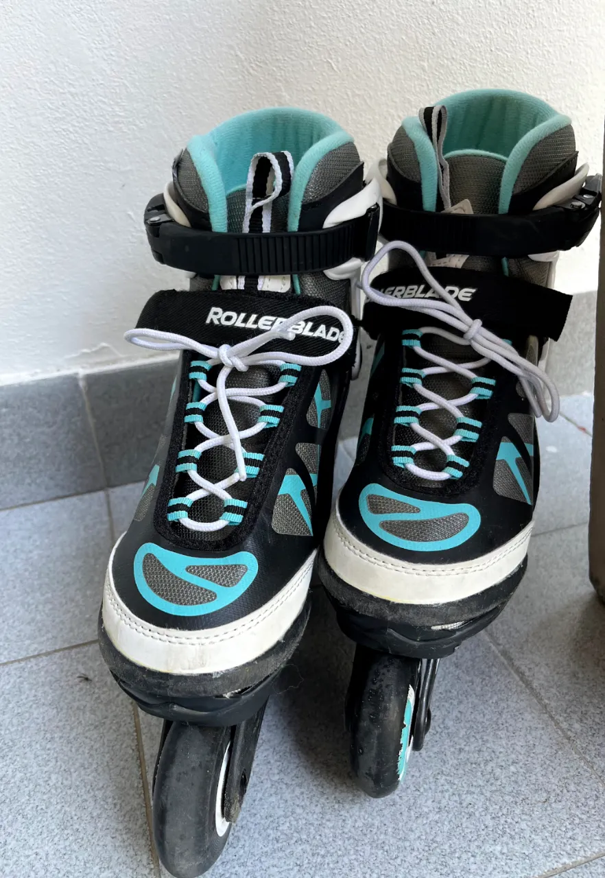 Patines Rollerblade regulables del talle 32 al 37 (US 1 al US 5.5), color negro y celeste, con detalles en blanco. Ideales para disfrutar del patinaje. 