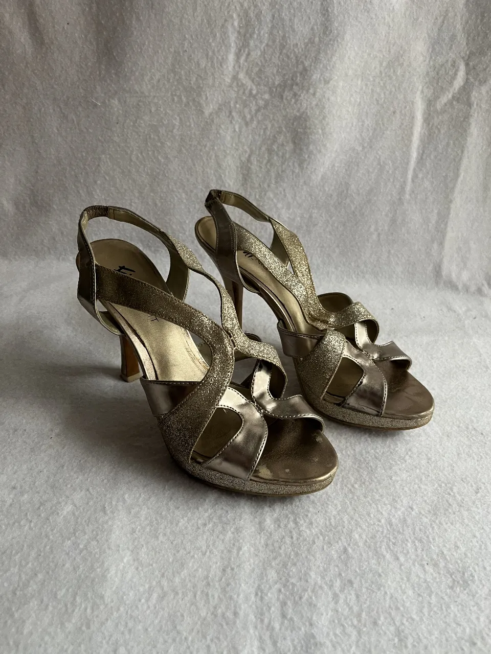 Sandalias de fiesta doradas con detalles brillantes. Ideales para eventos especiales y celebraciones.