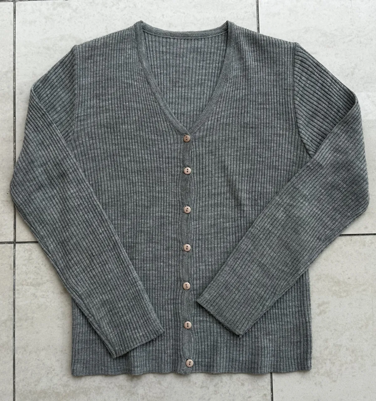 Cardigan de tejido de punto acanalado con cuello en V y botones al frente.