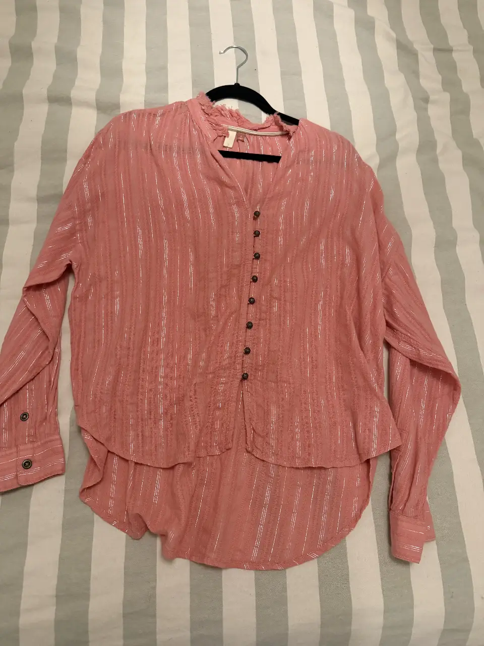Blusa rosa con detalles brillantes y botones. Ideal para un look casual y femenino.