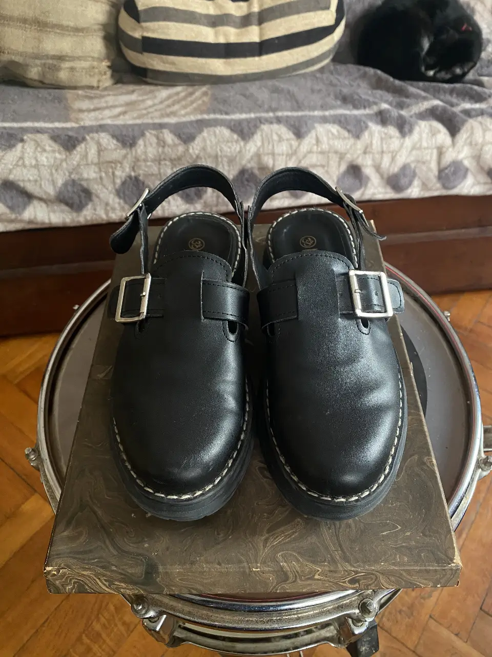 Zuecos negros con hebillas y suela gruesa, ideales para un look moderno y cómodo. Perfectos para combinar con diferentes outfits.