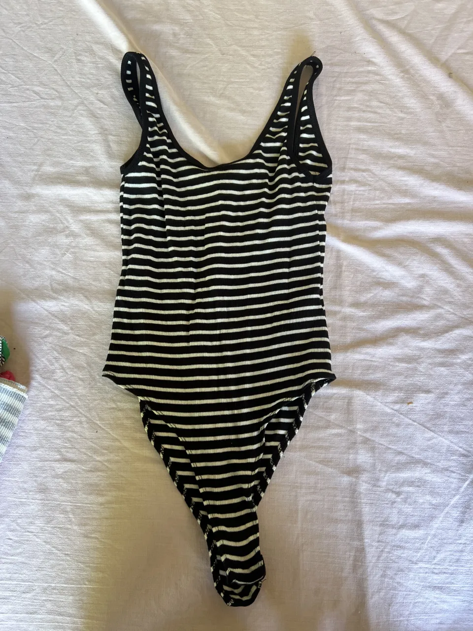 Body de rayas blancas y negras con broches inferiores.