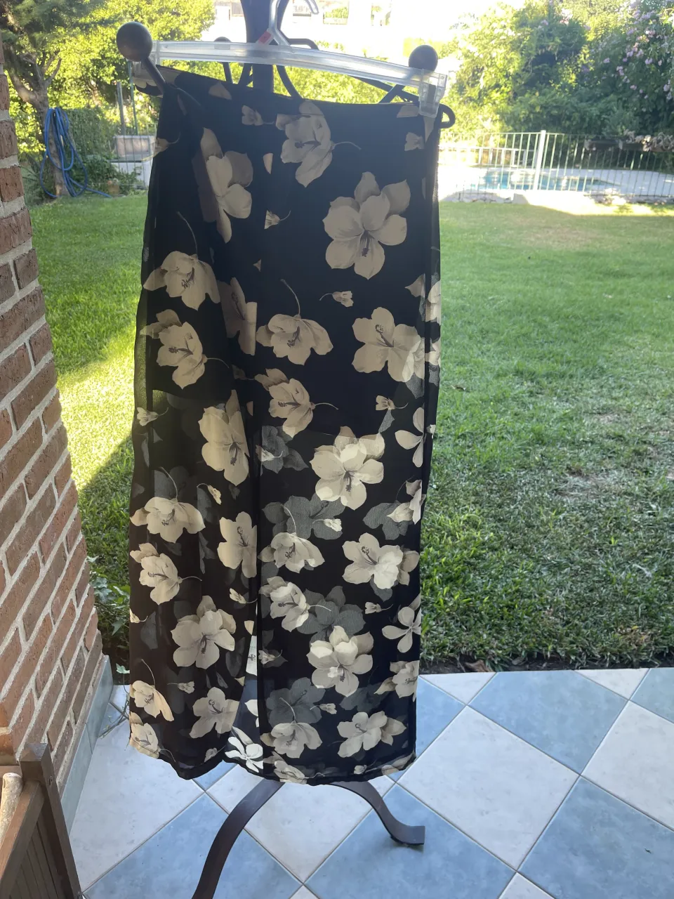 Pollera larga estampada con flores blancas y grises sobre fondo negro. tela tipo gasa con forro corto. cintura 34cm largo 88 cm