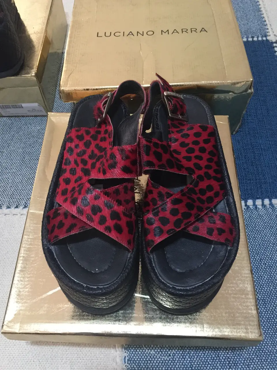 Sandalias de plataforma con estampado de leopardo en rojo y negro. Diseño de Luciano Marra, ideales para un look audaz y moderno.