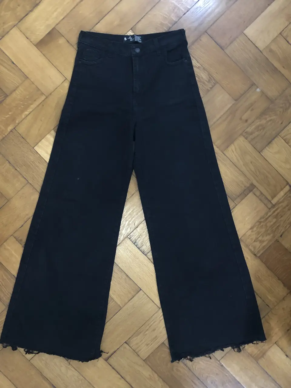 Pantalón de jean negro de corte recto y tiro alto, con un estilo wide leg. Ideal para un look casual y moderno.