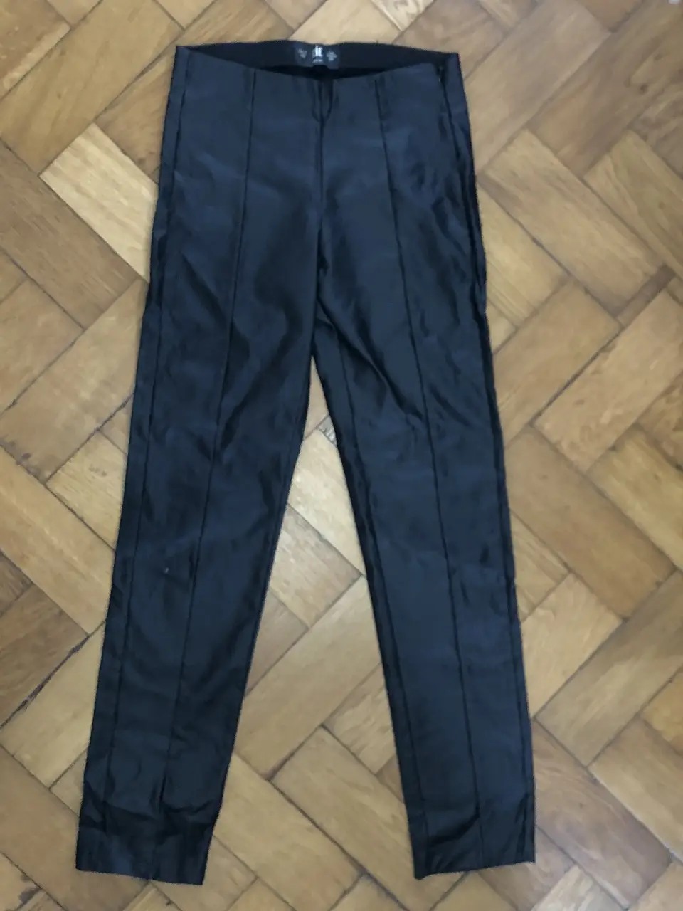 Pantalón Engomado RÍE. Color negro, con detalles de costuras verticales. Talle 40. Ideal para un look elegante y sofisticado.