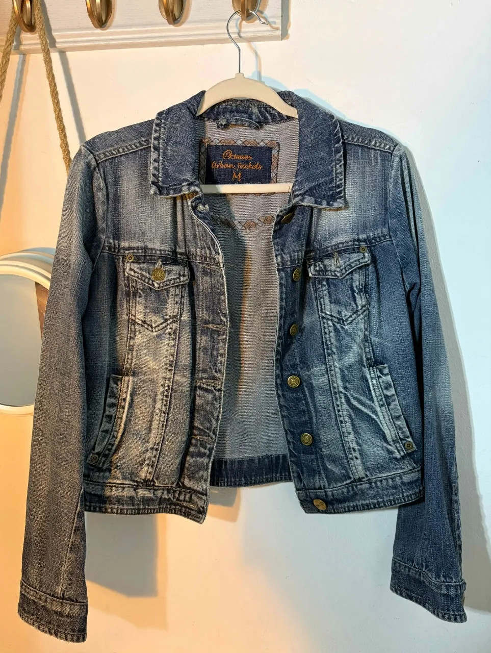 Campera de jean azul, estilo clásico, con bolsillos delanteros y botones dorados. Ideal para un look casual y versátil.