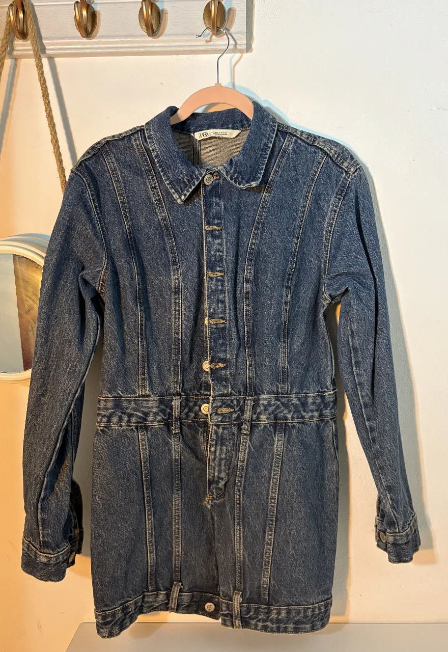 Vestido mini de jean azul de la marca Zara, con botones frontales y detalles de costura. Ideal para un look casual y moderno.