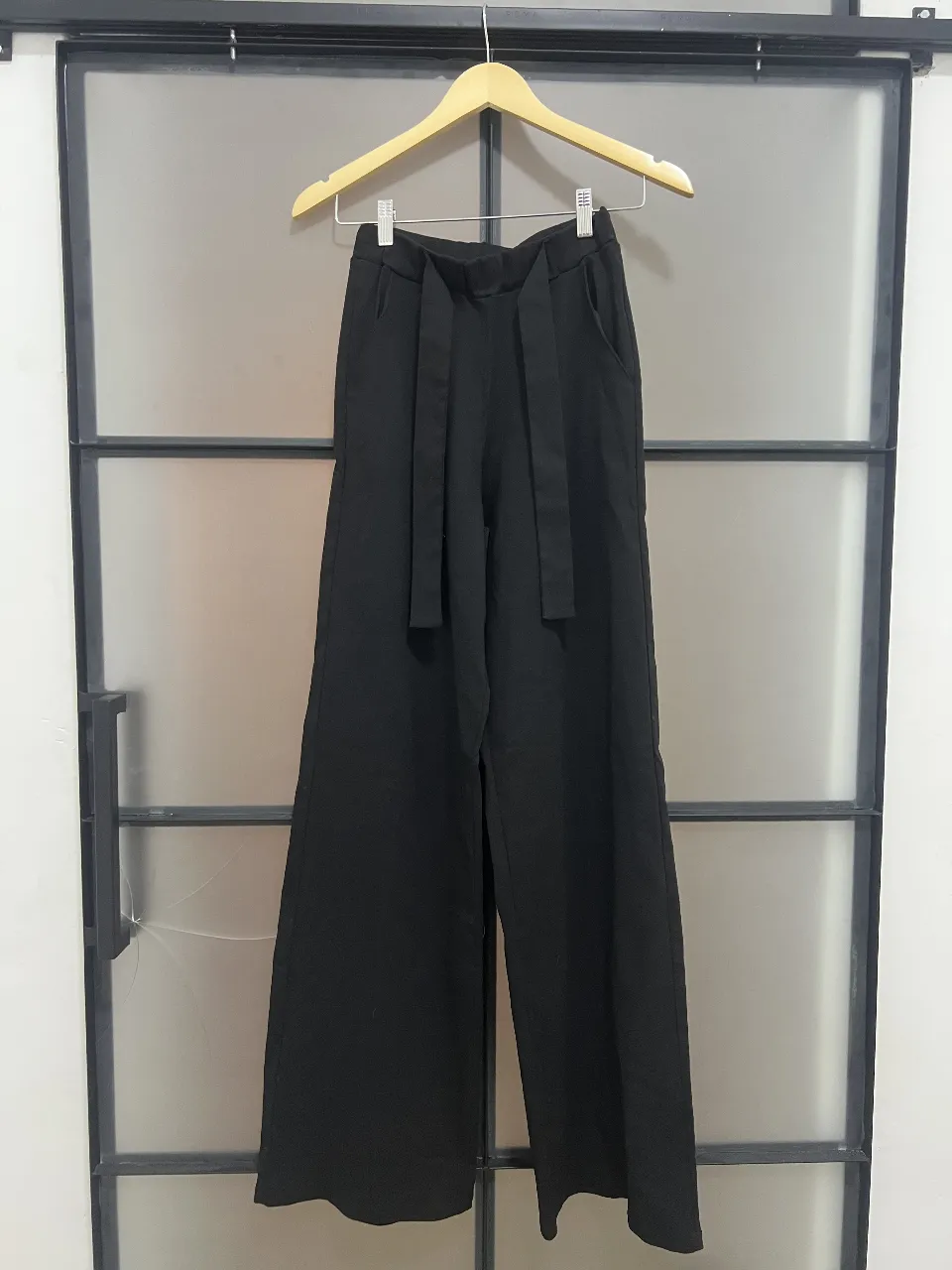 Pantalón sastrero negro con lazo en la cintura. Corte amplio y elegante, ideal para un look formal o de trabajo.