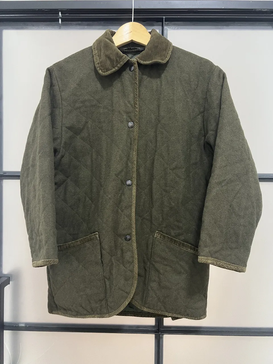 Campera de hombre estilo Barbour, color verde oliva, con cuello de pana marrón. Posee dos bolsillos delanteros amplios y cierre con botones. Ideal para el invierno.