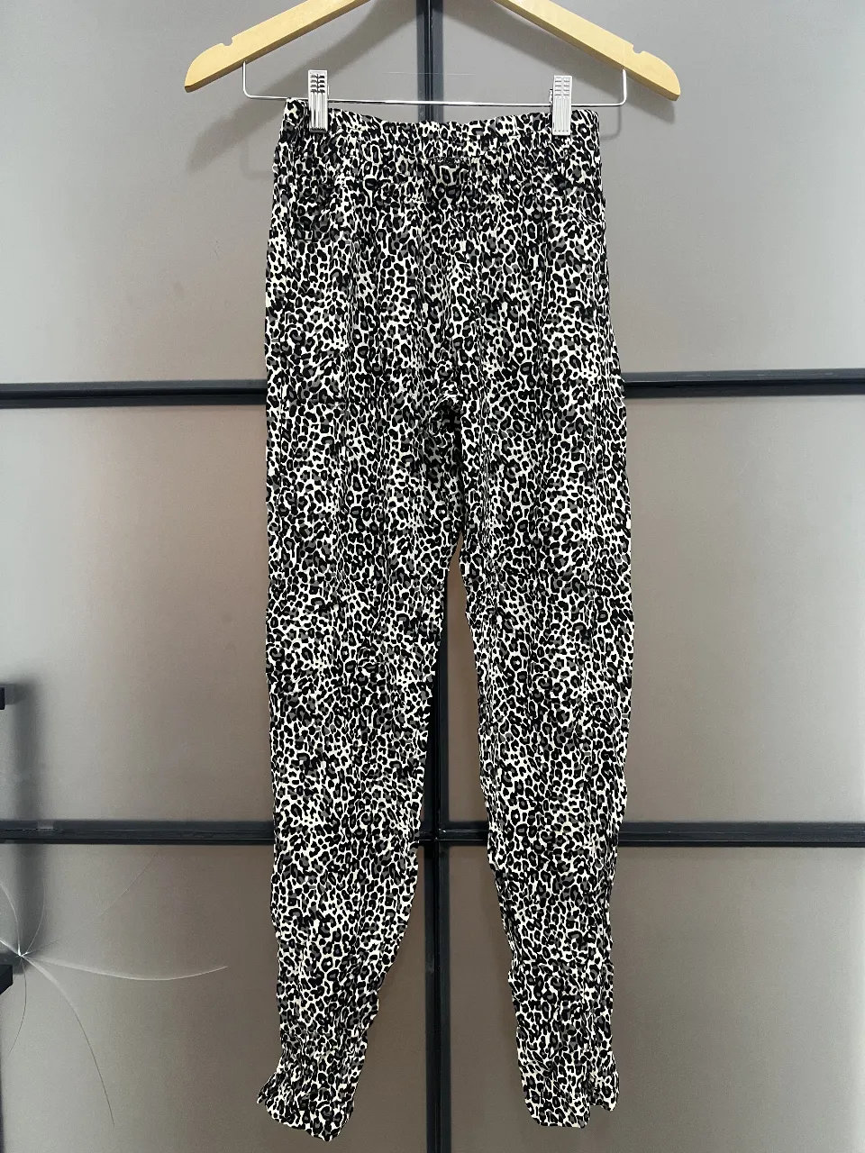 Pantalón suelto con estampado de leopardo en blanco y negro. Ideal para un look casual y moderno.