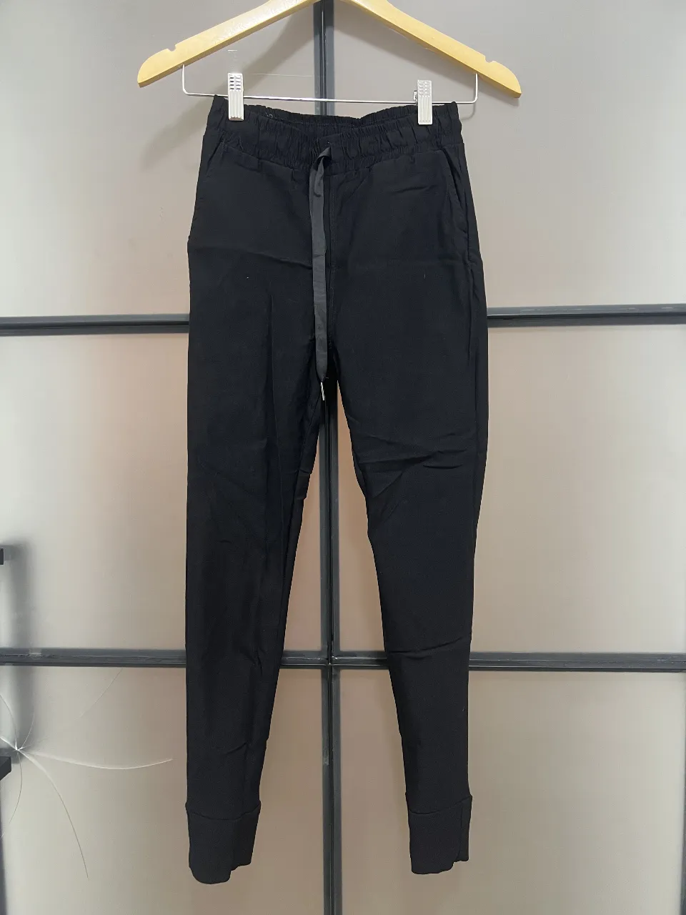 Pantalón chino negro para hombre, con cintura elastizada y cordón. Ideal para un look casual y cómodo.