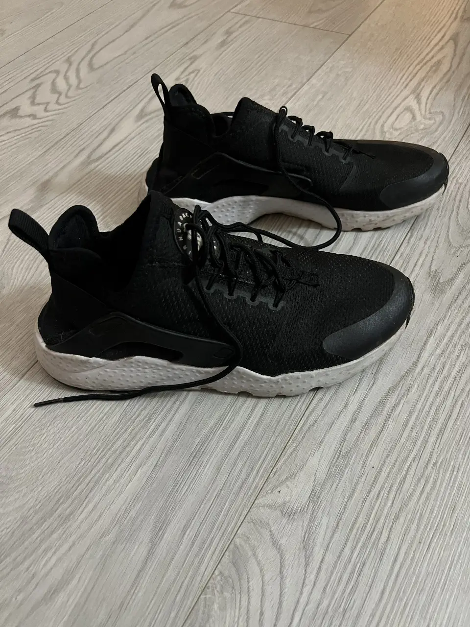 Zapatillas Nike Air Huarache negras con detalles blancos. Talle 8.5 US. Ideales para uso diario y actividades deportivas.