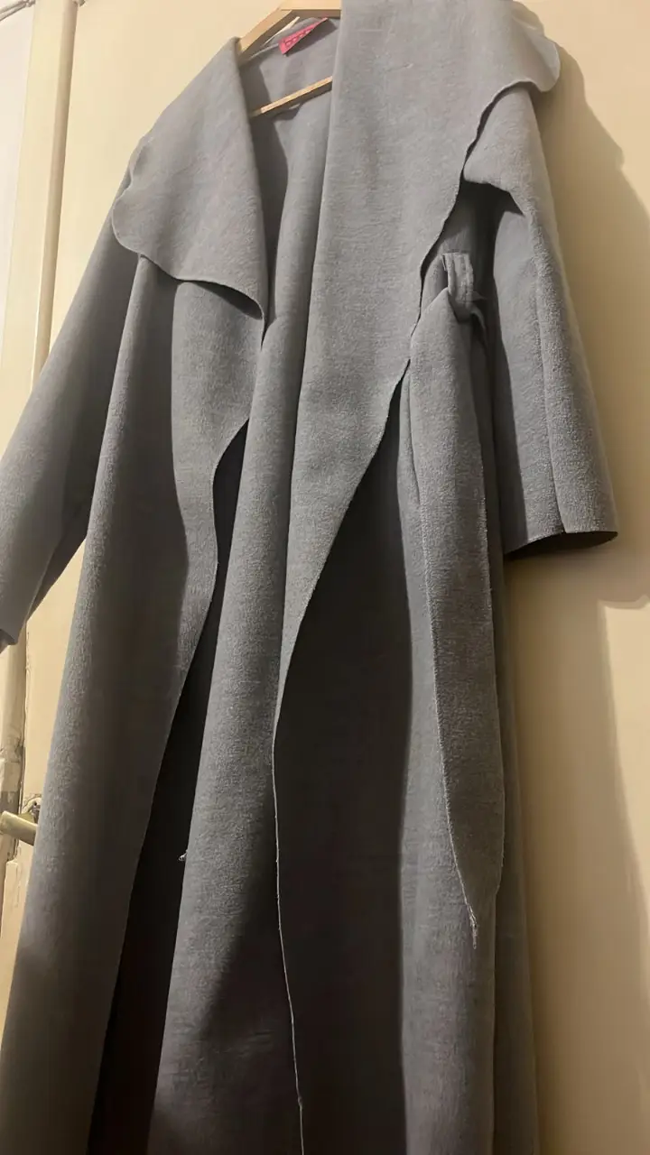 Sobretodo largo de paño gris, con solapas amplias y diseño envolvente. Ideal para un look elegante y abrigado en invierno.