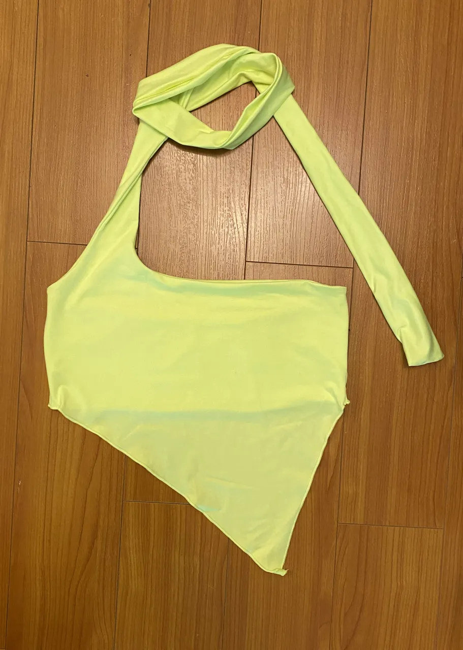 Top asimétrico en color amarillo neón, ideal para lucir en fiestas o salidas nocturnas. 
