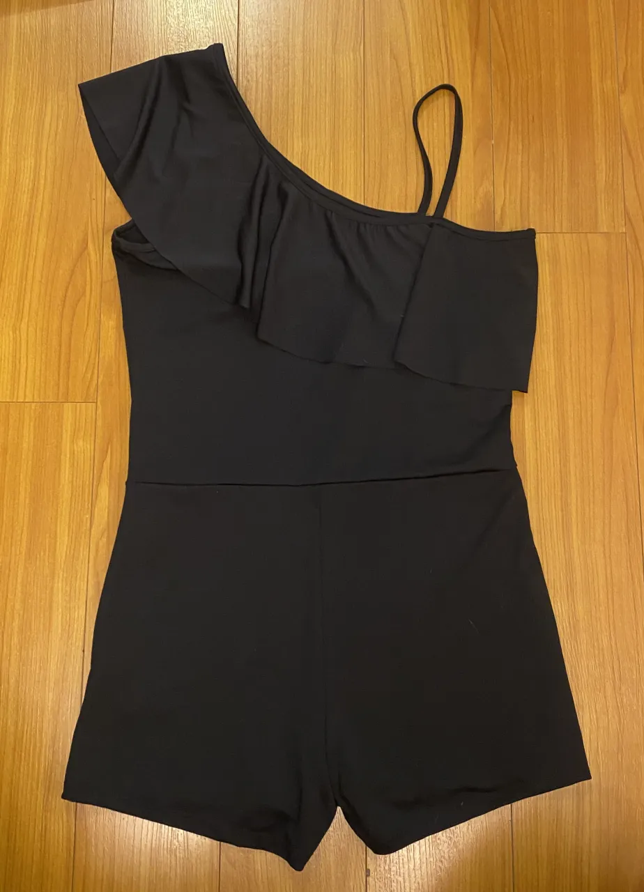 Mono negro de una sola manga con volado. Ideal para un look canchero y moderno.