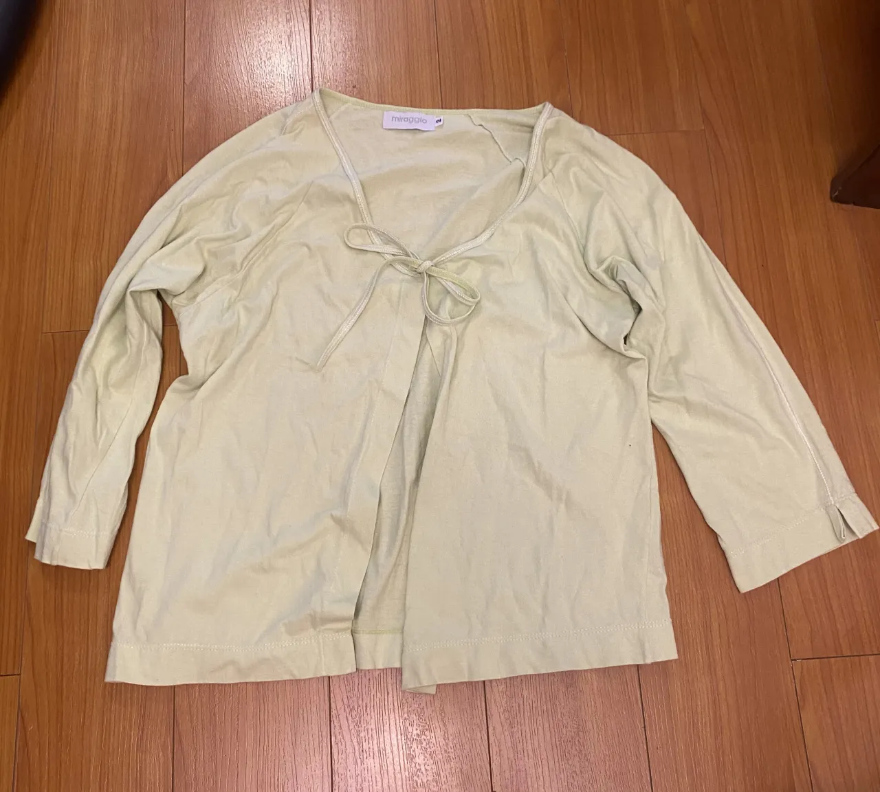 Remera de manga 3/4, color verde pastel. Posee un lazo para atar en la parte delantera. Ideal para un look casual y fresco.