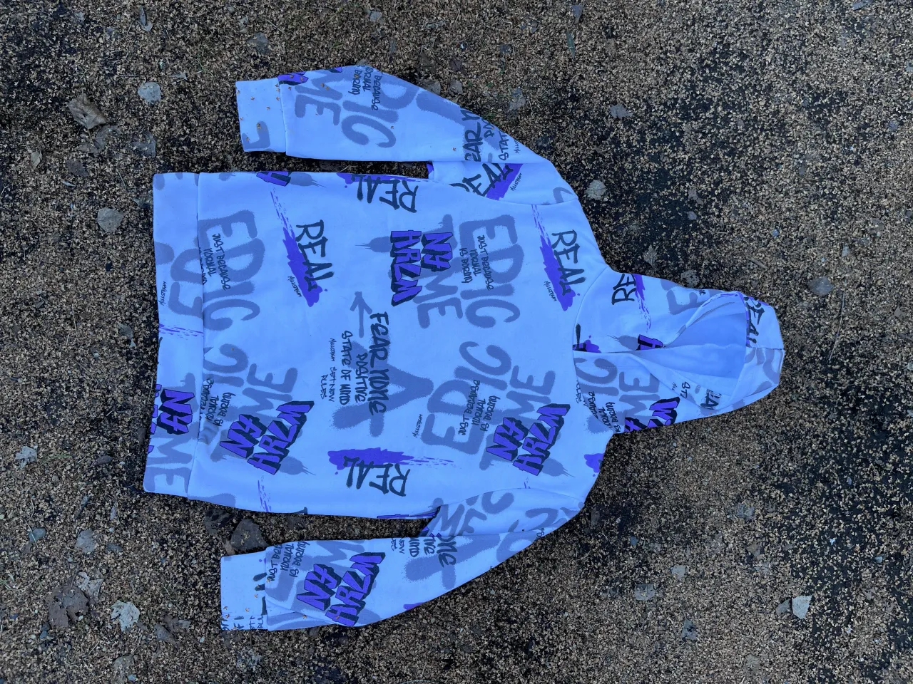 Hoodie oversize con estampa de letras y frases en blanco y violeta. Un diseño urbano y moderno, ideal para un look casual y descontracturado. Perfecto para combinar con jeans o pantalones cargo. Talle 10