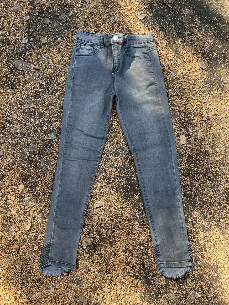 Jeans grises tiro alto con detalles en los tobillos. Un clásico que no puede faltar en tu guardarropa.