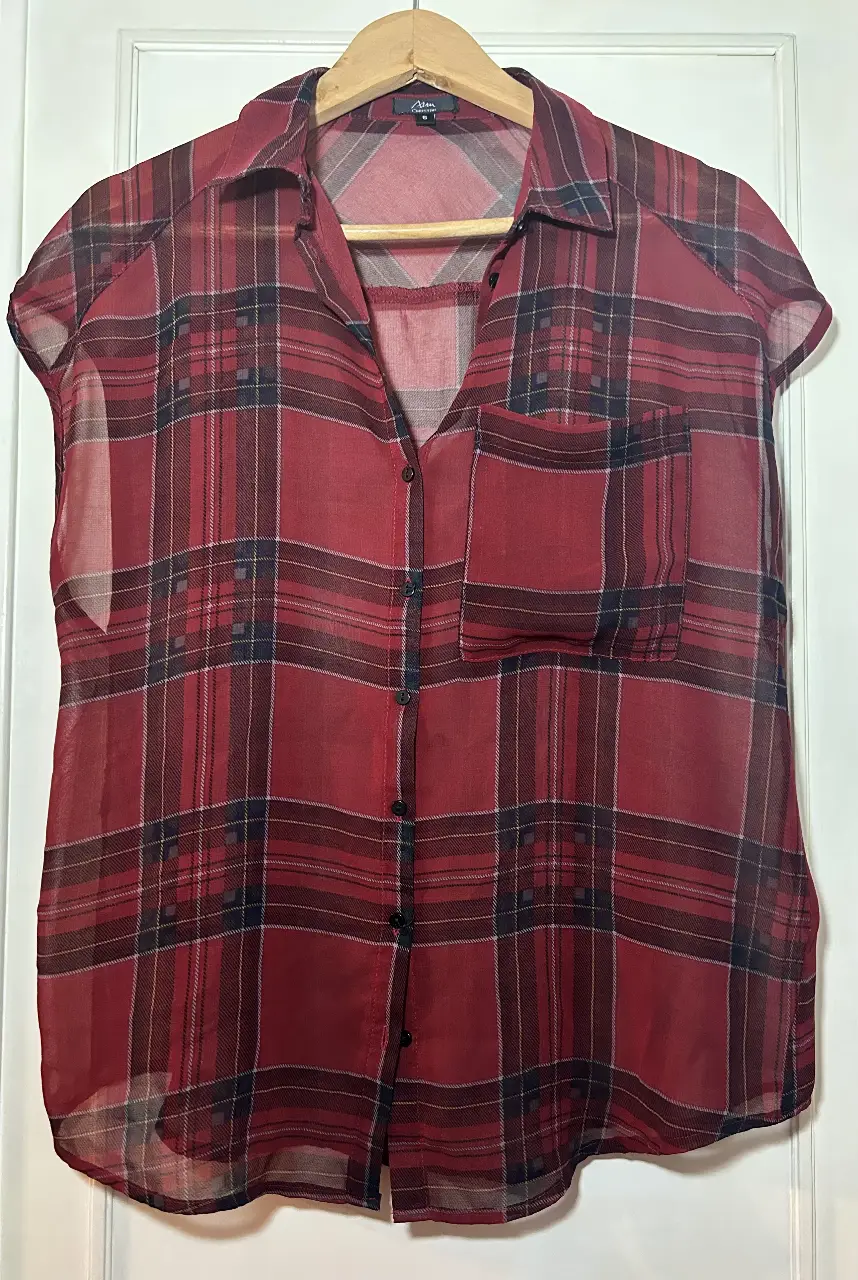 Camisa de mujer a cuadros rojos, con mangas cortas y un bolsillo en el pecho. Ideal para un look casual y cómodo.