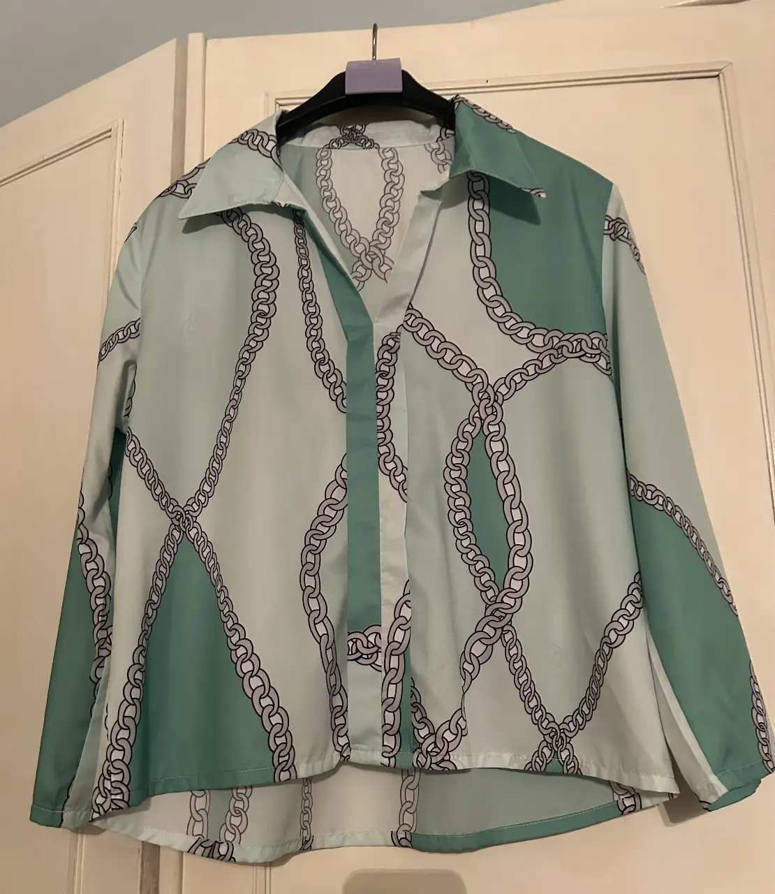 Camisa estampada con diseño de cadenas en tonos verde y blanco. Ideal para un look casual y moderno.